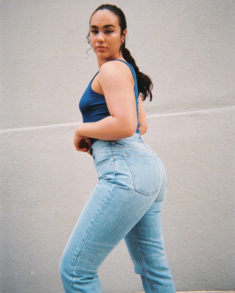 “Curvy woman in Everlane high-rise 90s jeans paired with loafers and neutral top”